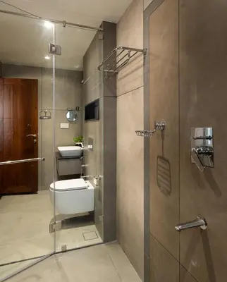 a bathroom with a shower with a toilet and a sink at Sanketam Motel in Calicut