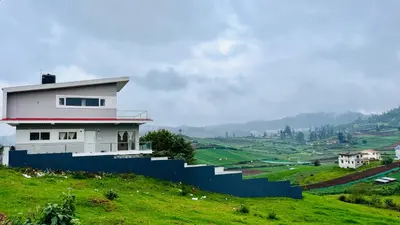 a house on a hill with a blue fence at Away From Home - 3 - Rooms In Ooty, Home Stay Ooty in Ooty