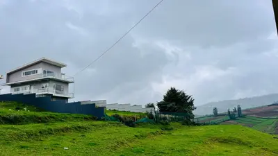 a house sitting on top of a green hill at Away From Home - 3 - Rooms In Ooty, Home Stay Ooty in Ooty