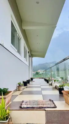 a balcony with potted plants on a building at Away From Home - 3 - Rooms In Ooty, Home Stay Ooty in Ooty