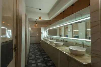 a bathroom with four sinks and a row of mirrors at Bharath Pods in Coimbatore