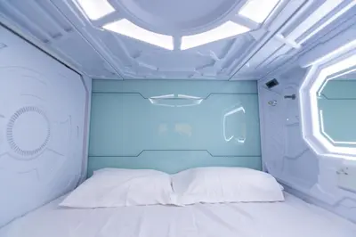 a bed in a room with a ceiling at Bharath Pods in Coimbatore