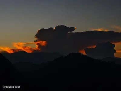a silhouette of a mountain with a sunset at May Fair Vista Luxury Villa - Huge Lawn - Scenic Views - Free Parking in Kotagiri