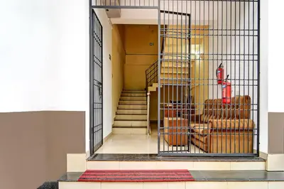 a cage with chairs and stairs in a building at Super Hotel O West Hill near Mietra Hospital in Calicut