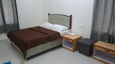 a small bedroom with a bed and a night stand at Ooty Blue Mountain Villa Thalayathimund in Ooty