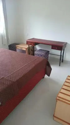 a bedroom with a desk and a bed with two chairs at Ooty Blue Mountain Villa Thalayathimund in Ooty