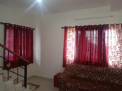 a living room with red curtains and a couch at Ooty Blue Mountain Villa Thalayathimund in Ooty