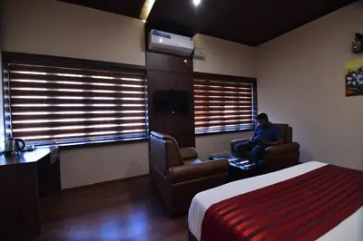 a man sitting in a chair in a hotel room at Garuda Luxury Bungalow in Trichūr
