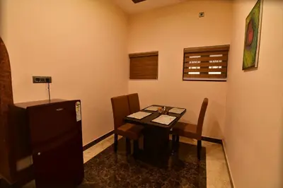 a small dining room with a table and chairs at Garuda Luxury Bungalow in Trichūr