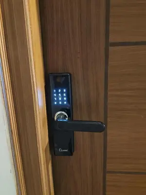a black door handle on a wooden door at Posh 1 BHK Apt with Temple View in Guruvayur C1301 in Guruvāyūr
