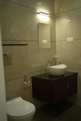 a bathroom with a sink and a toilet and a mirror at Golden Sands Cherai in Cherai Beach