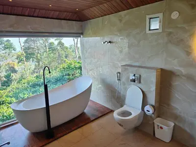 a bathroom with a tub and a toilet and a window at The Cozy Clouds Hill Stay in Napoklu