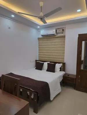 a bedroom with a bed with a ceiling fan at Posh 1 BHK Apt with Temple View in Guruvayur B1001 in Guruvāyūr