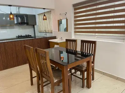 a kitchen with a dining room table and chairs at RoyalGiri Apartment near Rajagiri Hospital in Alwaye