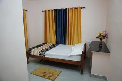 a small bed in a room with a curtain at Mankulam Holidays Homestay in Viripara