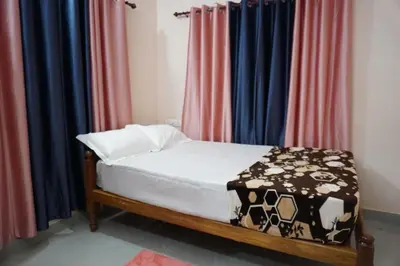 a bed in a room with colorful curtains at Mankulam Holidays Homestay in Viripara