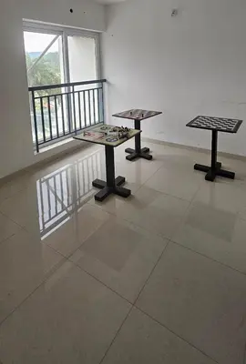 two tables in an empty room with a window at Aaram Miraj Luxuria Apartment -1 in Wayanad