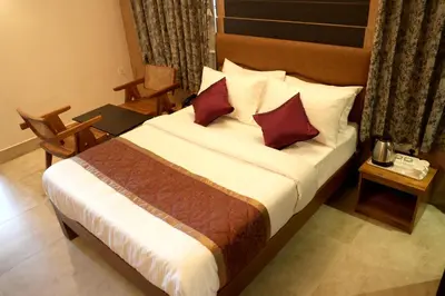 a hotel room with a large bed with red pillows at Hotel Orchard Coorg in Virajpet
