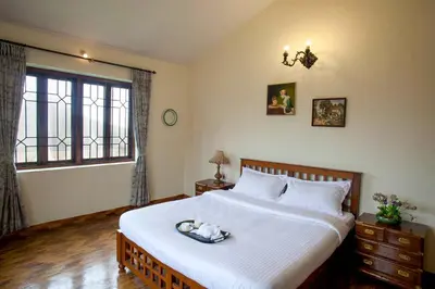 a bedroom with a large bed and a window at Away From Home - 2 - Rooms In Ooty, Home Stay Ooty in Ooty