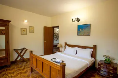 a bedroom with a large bed with white sheets at Away From Home - 2 - Rooms In Ooty, Home Stay Ooty in Ooty