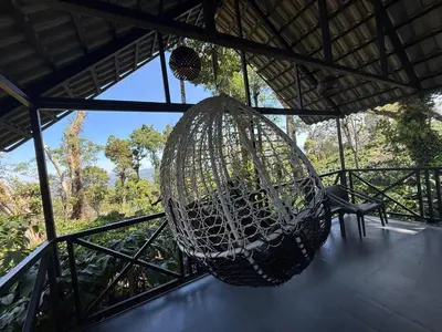 a hammock hanging from the roof of a house at The Cozy Clouds Hill Saty in Madikeri