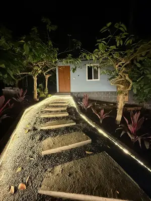 a walkway in front of a house at night at The Cozy Clouds Hill Saty in Madikeri