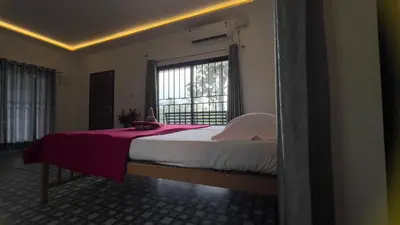 a bedroom with a large bed with a window at Lilliput Haven Homestay in Sultan Bathery