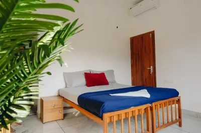 a bed in a room with a red pillow on it at Lilliput Haven Homestay in Sultan Bathery