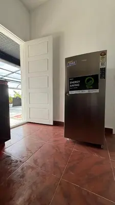 a refrigerator sitting in a room next to a door at Leafy Mist Villa in Munnar