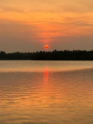 a sunset over a large body of water at Green Haven Homestay in Kodungallūr