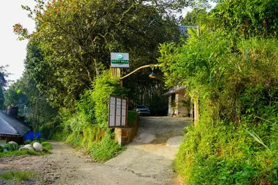 a house with a sign on the side of a road at Misty Hills Cabin in Wayanad