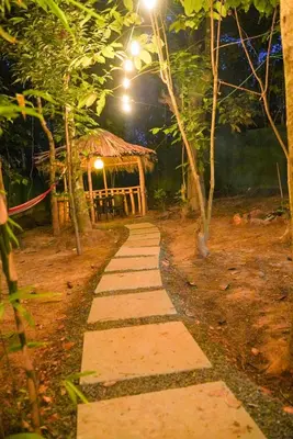a pathway leading to a gazebo at night at Misty Hills Cabin in Wayanad