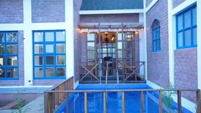 a porch of a brick building with a wooden railing at Preserve Ooty in Ooty