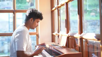 a man playing an organ in a room with windows at Preserve Ooty in Ooty