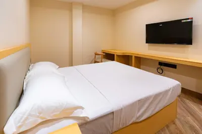 a hotel room with a bed and a flat screen tv at The Paradise International Hotel in Coimbatore