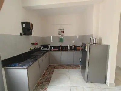 a kitchen with a refrigerator and a counter top at 7 Elysee Homestay - Safire - Premium 3BHK Family Flat in Trichūr