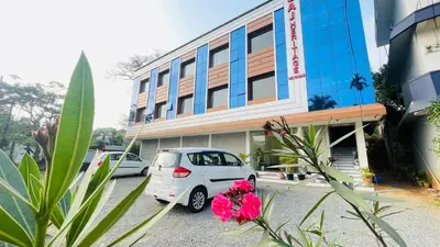 a white car parked in front of a building at Saj Heritage in Kalpetta
