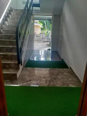 a stairwell with green flooring in a house at Stay Castle in Guruvāyūr