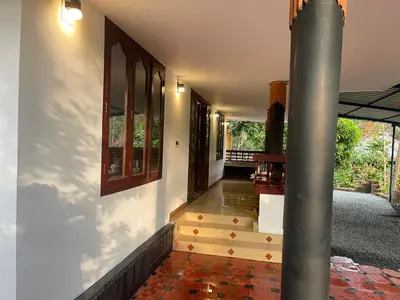 a hallway of a house with stairs and a pole at Rock Hill - Pachakkad Home Stay in Athirappally