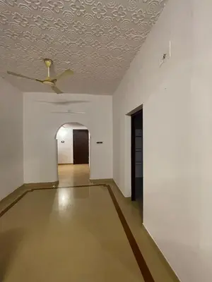 an empty room with a ceiling fan and a hallway at Rock Hill - Pachakkad Home Stay in Athirappally