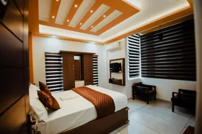 a bedroom with a bed and a desk in it at Crystal Winter Arcade wayanad in Wayanad
