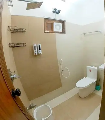 a bathroom with a shower with a toilet and a sink at Entire Villa Homestay Rooms IRITTY in Irrity