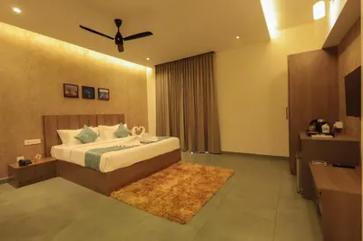 a bedroom with a bed and a ceiling fan at Holidays Garden Resort in Kalpetta