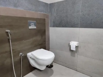 a bathroom with a white toilet in a stall at Holidays Garden Resort in Kalpetta