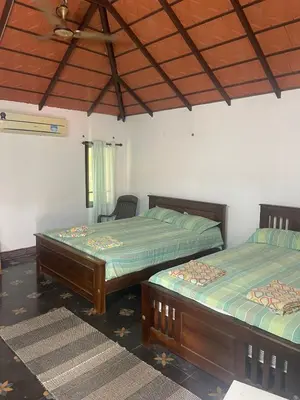 a bedroom with two beds and a ceiling at Yes Yes Farms in Pollāchi