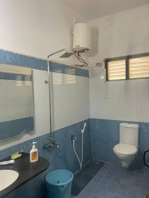 a bathroom with a toilet and a sink and a mirror at Yes Yes Farms in Pollāchi