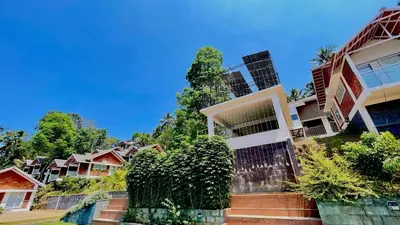 a row of houses with trees in front of them at Monarda Resort in Padinjarathara