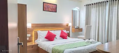 a bedroom with a large bed with red pillows at Sree Nandhanam apartment's in Guruvāyūr