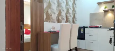a room with a kitchen with a table and a microwave at Sree Nandhanam apartment's in Guruvāyūr