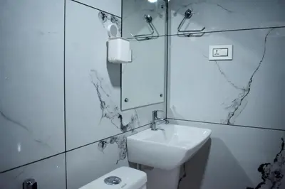 a bathroom with a sink and a mirror and a toilet at Forest Brew Resort Wayanad in Chekadi